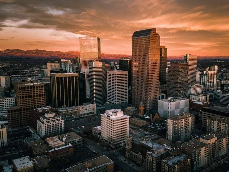 Downtown Denver, Colorado skyline at sunset with commercial buildings, surrounding properties, and urban development areas relevant to land surveying and site planning
